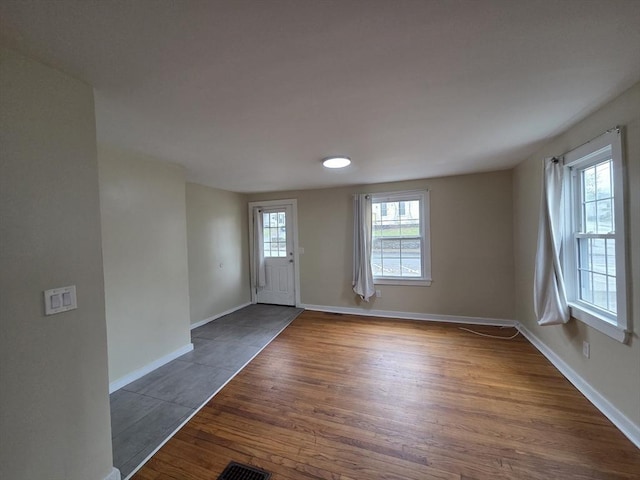 entryway featuring baseboards, dark wood finished floors, and visible vents