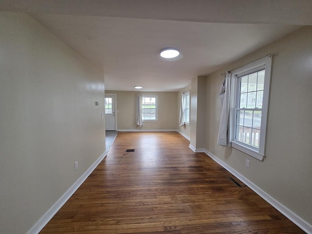 interior space with baseboards, dark wood-style flooring, and visible vents