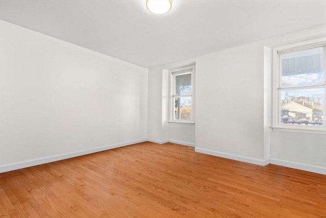 empty room with light hardwood / wood-style flooring