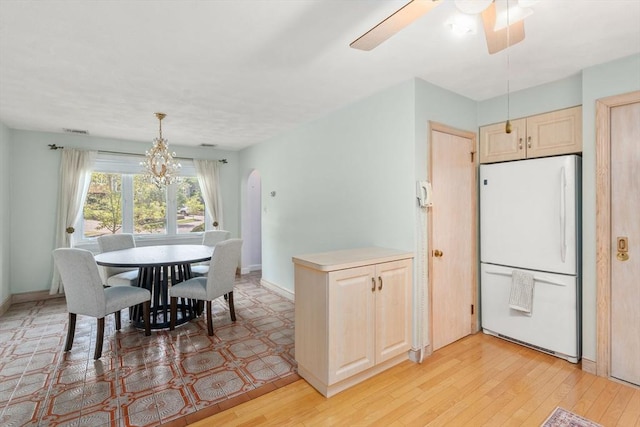 68 Shelton Rd, Swampscott, MA 01907 - dining room featuring arched walkways, a chandelier, ceiling fan, light wood-type flooring, and baseboards