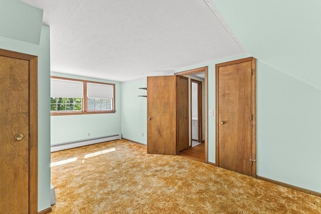 additional living space featuring a baseboard radiator, carpet, and vaulted ceiling