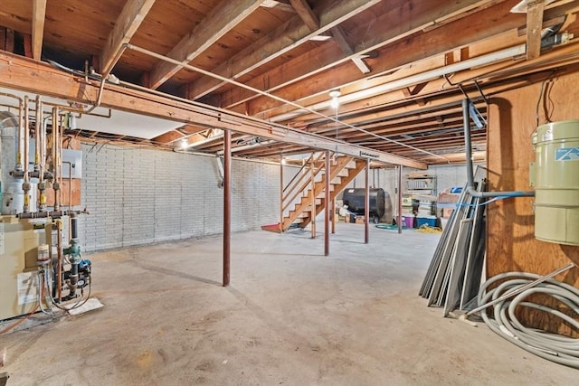 unfinished below grade area with stairway, oil tank, a heating unit, and a central vacuum unit