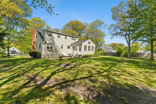 back of house featuring a chimney and entry steps