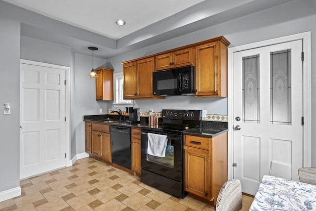 kitchen with baseboards, decorative light fixtures, brown cabinetry, black appliances, and a sink