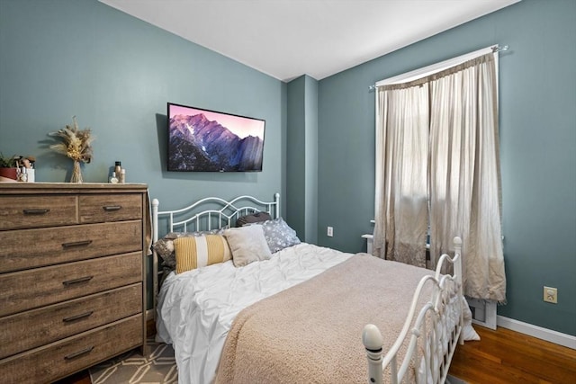 bedroom featuring baseboards and dark wood-style floors