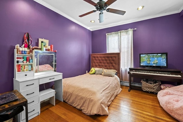 bedroom featuring a baseboard heating unit, a ceiling fan, crown molding, and hardwood / wood-style flooring