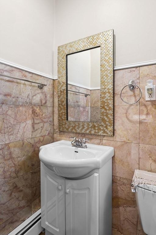 bathroom with a baseboard heating unit, tile walls, and vanity