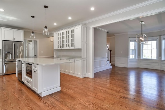 kitchen with light countertops, glass insert cabinets, white cabinets, and stainless steel appliances