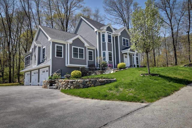 view of front of property with a garage, a front lawn, and aphalt driveway