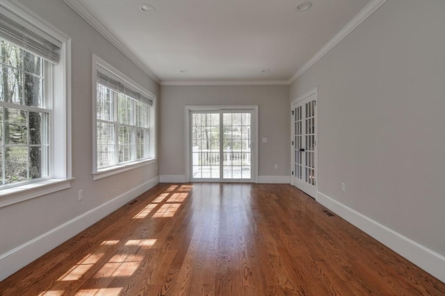 unfurnished room featuring baseboards, ornamental molding, and wood finished floors