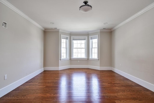 spare room with baseboards, ornamental molding, wood finished floors, and visible vents