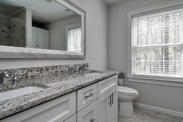bathroom with a sink, plenty of natural light, a stall shower, and toilet