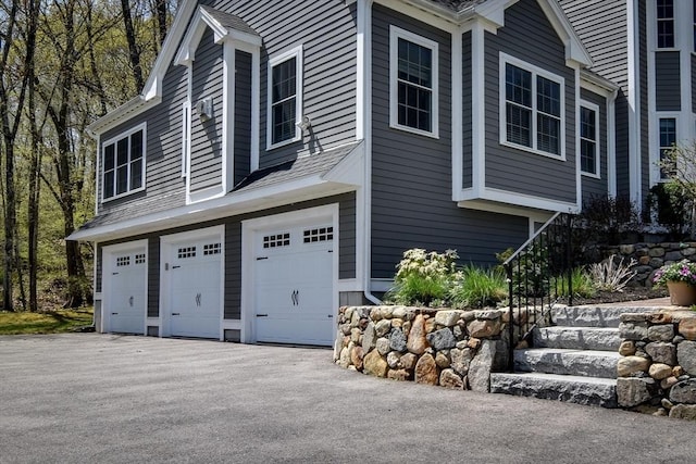 view of side of property with an attached garage and driveway