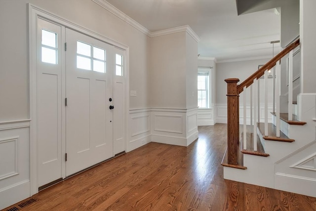 entryway featuring crown molding, visible vents, wood finished floors, and stairway