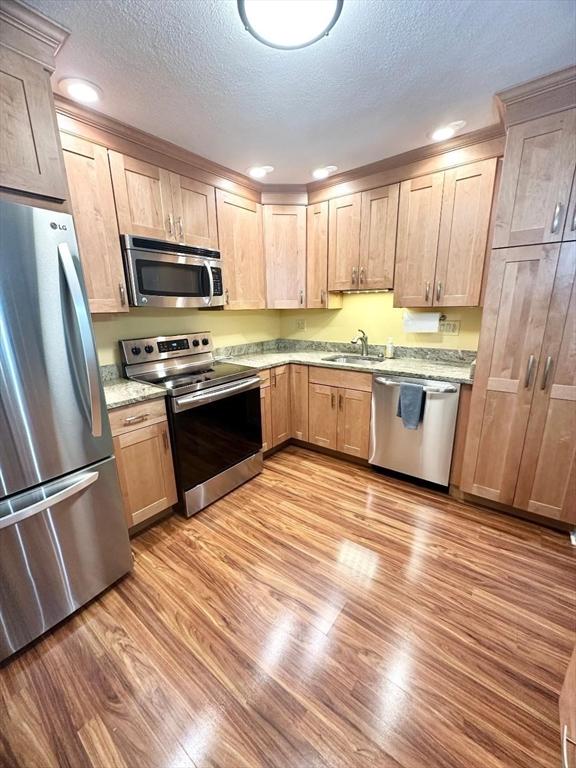 6 Tamarack Ln Unit 6, Peabody, MA 01960 - kitchen with stainless steel appliances, light wood-type flooring, light brown cabinets, a textured ceiling, and recessed lighting