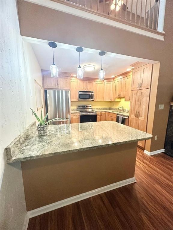6 Tamarack Ln Unit 6, Peabody, MA 01960 - kitchen with appliances with stainless steel finishes, dark wood-type flooring, light brown cabinets, a peninsula, and light stone counters