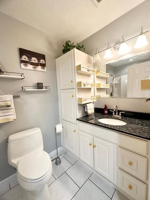 6 Tamarack Ln Unit 6, Peabody, MA 01960 - bathroom featuring vanity, tile patterned flooring, a textured ceiling, and a shower