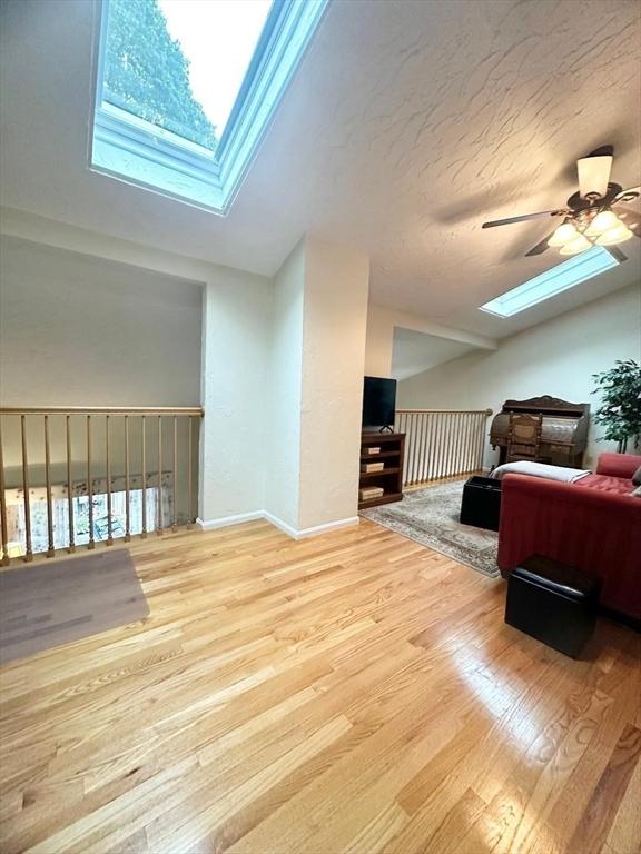 6 Tamarack Ln Unit 6, Peabody, MA 01960 - bedroom featuring a skylight, wood finished floors, vaulted ceiling, and ceiling fan