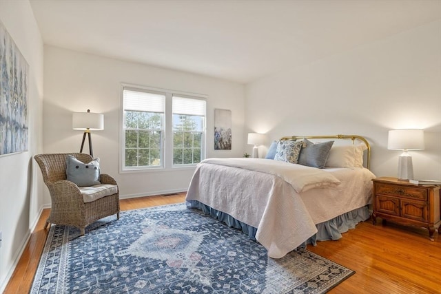 bedroom with baseboards and wood finished floors