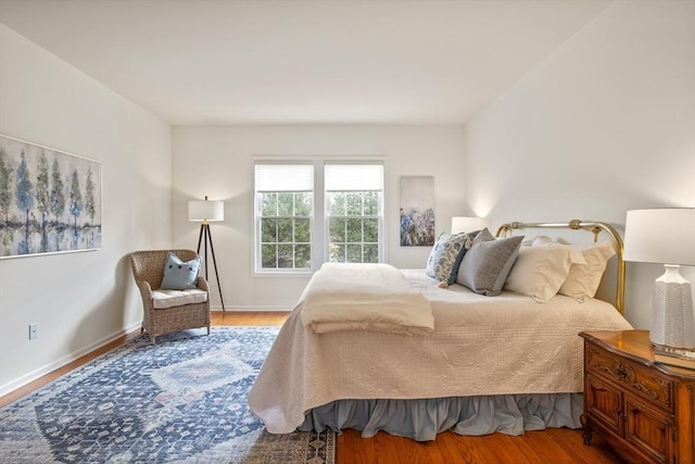 bedroom with wood finished floors and baseboards