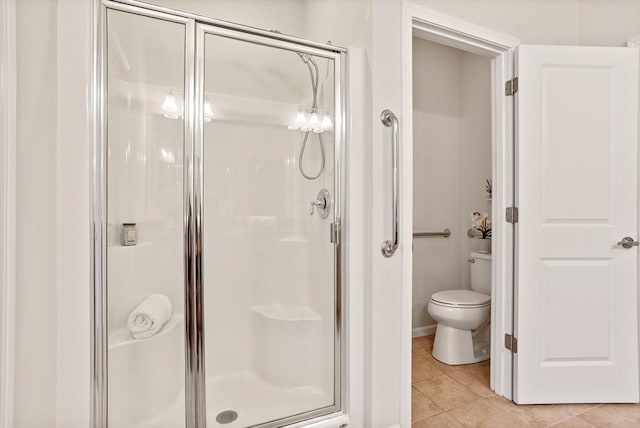 bathroom with toilet, a stall shower, and tile patterned flooring