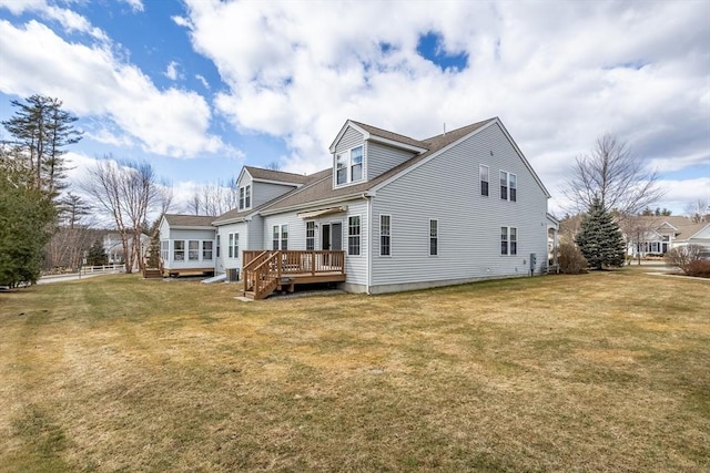 back of house featuring a lawn and a deck