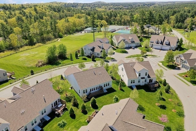 drone / aerial view featuring a residential view and a wooded view