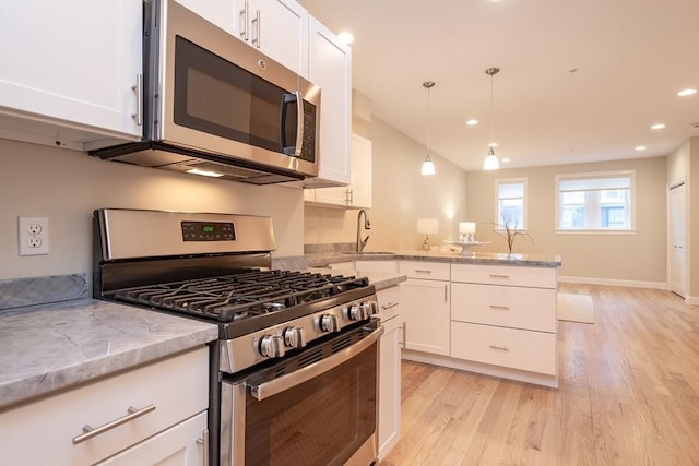 170 I St Unit 1, Boston, MA 02127 - kitchen with appliances with stainless steel finishes, light wood finished floors, white cabinets, and recessed lighting