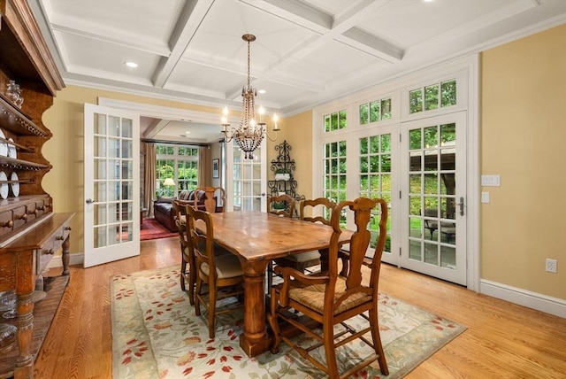 dining room with french doors, coffered ceiling, a chandelier, and light hardwood / wood-style floors