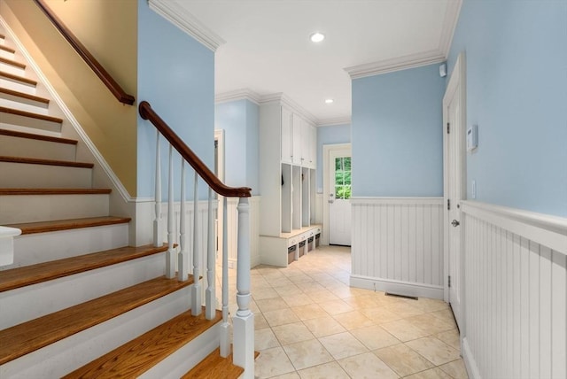 staircase with tile patterned flooring and ornamental molding