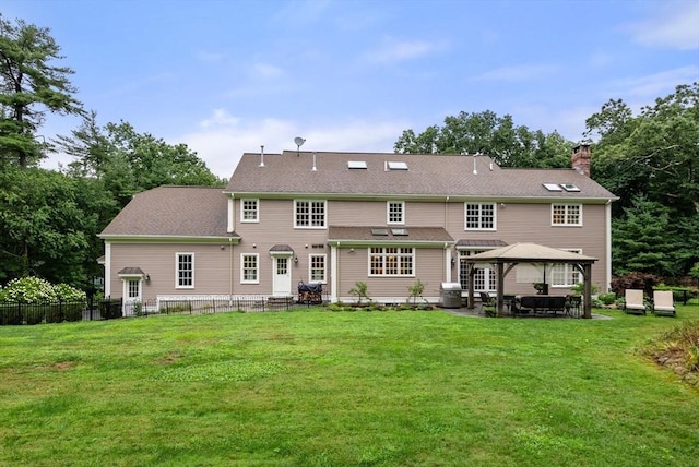 back of house with a gazebo and a lawn