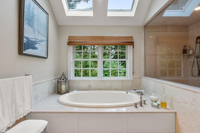 bathroom with a skylight and independent shower and bath