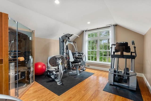 exercise room featuring hardwood / wood-style flooring and vaulted ceiling