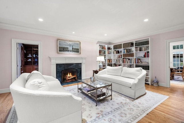 living room featuring a fireplace, ornamental molding, and light hardwood / wood-style floors