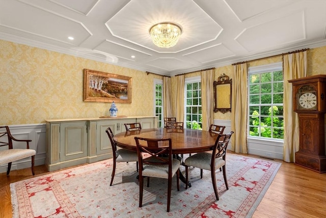 dining space featuring coffered ceiling, light wood-type flooring, ornamental molding, and an inviting chandelier