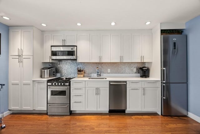 kitchen featuring a sink, light countertops, baseboards, white cabinets, and stainless steel appliances