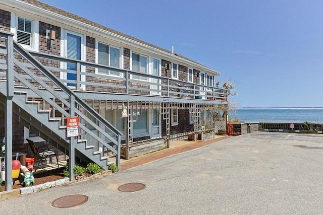 view of property with stairway and a water view