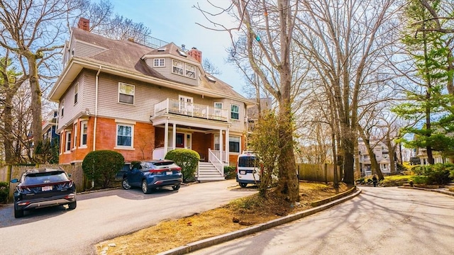 view of front of property featuring a balcony and a chimney