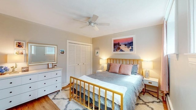 bedroom with wood finished floors, a closet, baseboards, and ceiling fan