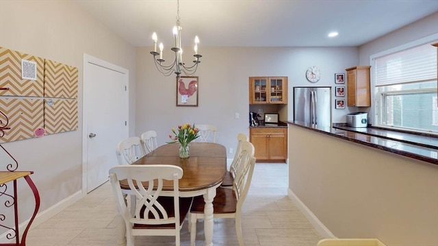 dining space featuring a chandelier and baseboards