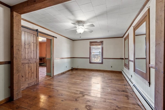 unfurnished room with a barn door, ornamental molding, a ceiling fan, and hardwood / wood-style flooring