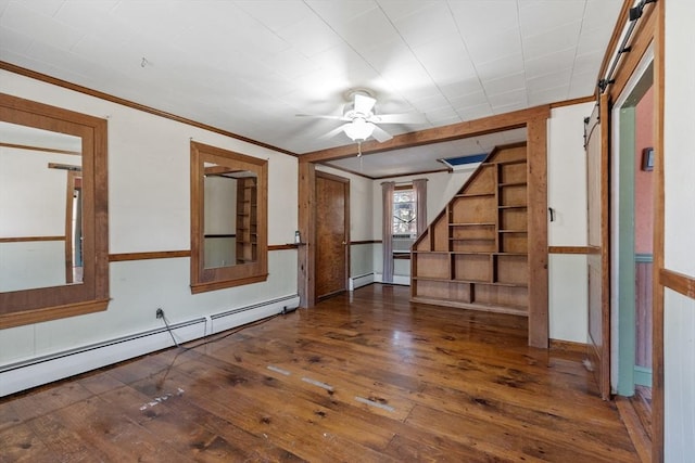 empty room featuring hardwood / wood-style floors, crown molding, stairway, and a baseboard radiator