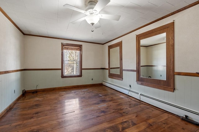 spare room with crown molding, a wainscoted wall, baseboard heating, a ceiling fan, and wood-type flooring