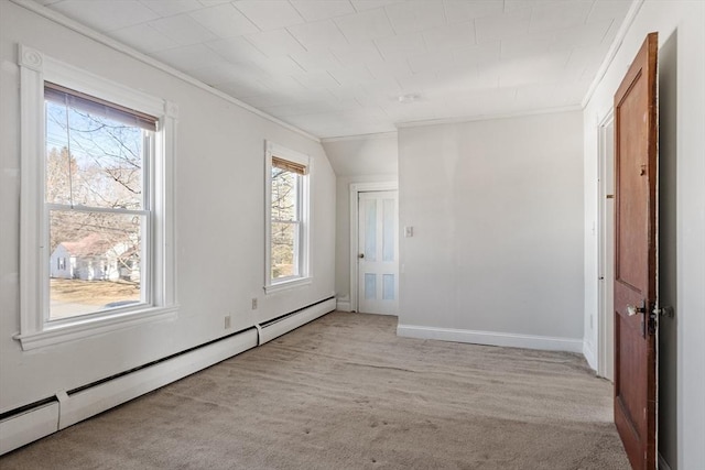 carpeted empty room featuring a baseboard heating unit, baseboards, and ornamental molding