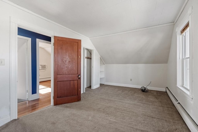 additional living space featuring a baseboard heating unit, lofted ceiling, baseboards, and carpet floors