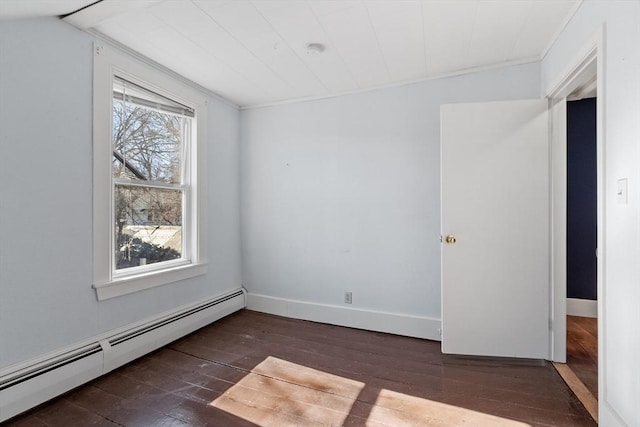 spare room featuring baseboards, baseboard heating, and dark wood-style floors