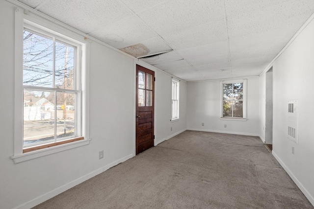 spare room featuring a paneled ceiling, baseboards, and carpet floors