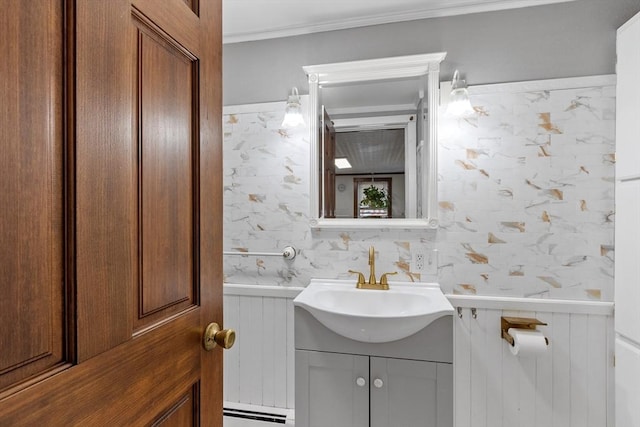 half bathroom with a baseboard radiator, vanity, and crown molding