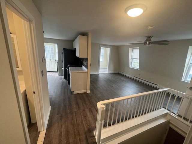 kitchen featuring dark wood-type flooring, a baseboard heating unit, ceiling fan, tasteful backsplash, and white cabinetry