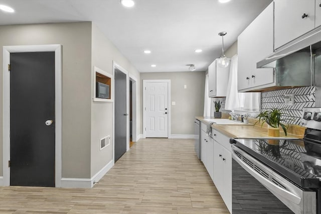 kitchen featuring visible vents, appliances with stainless steel finishes, light countertops, white cabinetry, and a sink